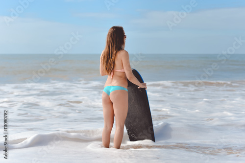 Picture of beautiful girl with bodyboard, ready for fun. Beach background