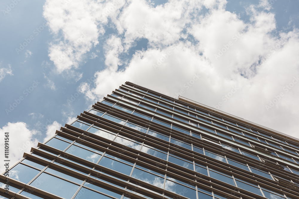 Angled view of a glass wall of an office building. Infinity effect in the blue sky.
Angled view of a glass wall of an office building. Infinity effect in the blue sky.