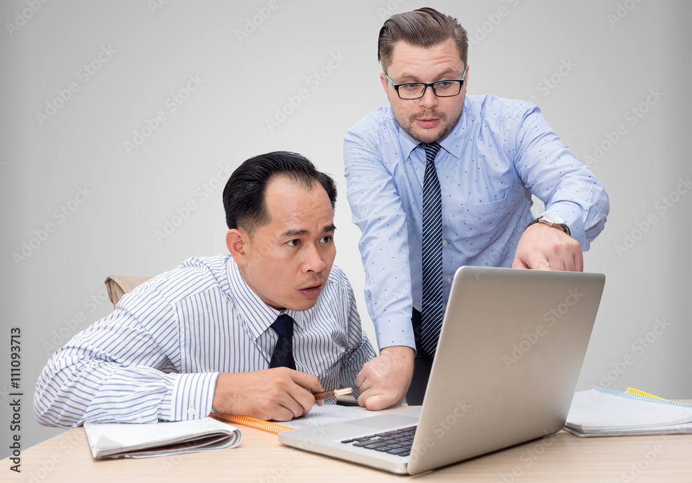 Two business people point finger on laptop
