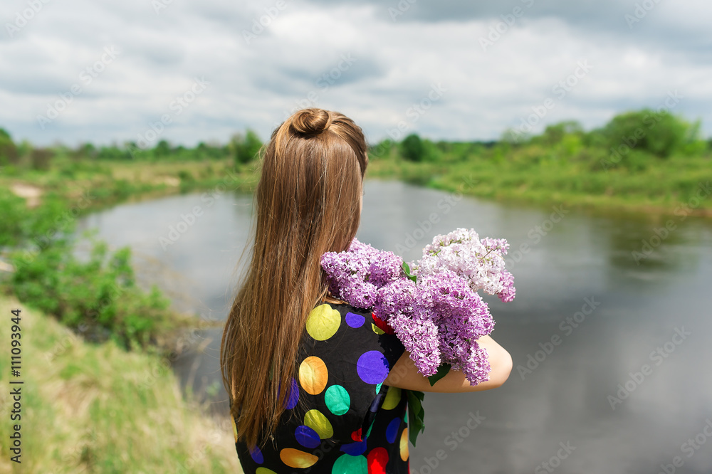 Naklejka premium The girl with bouquet of lilac.