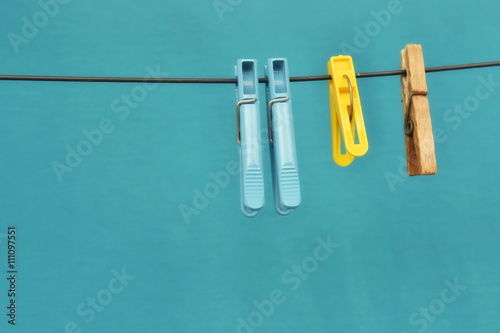 Clothespins on clothesline isolated on blue background