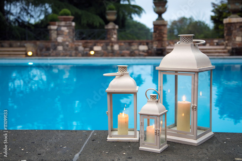 Traditional white lanterns in a garden with pool