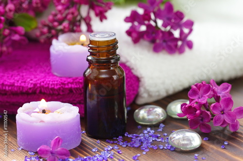 SPA setting with candles, aroma oil and lilac
