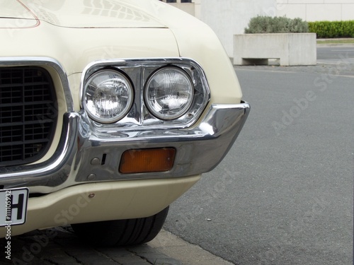 Fotografie Doppelscheinwerfer mit Chromeinfassung eines amerikanischen Coupé und Sportwagen