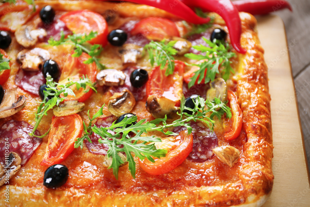 Rectangle delicious pizza and vegetables on the table, close-up