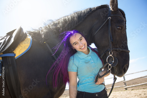 Beautiful teen girl on the farm with her horse.
