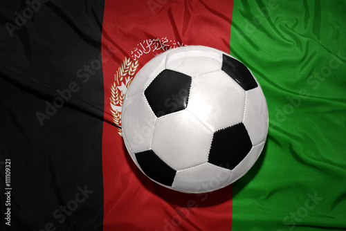 black and white football ball on the national flag of afghanistan