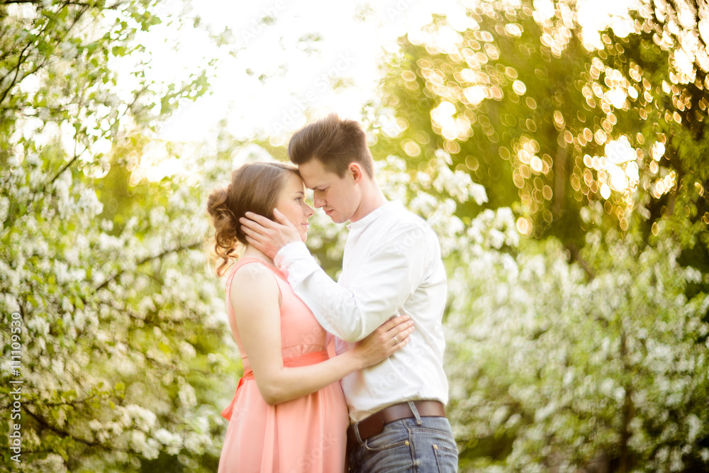 Couple in love under blooming branches spring day. Couple in love under blooming branches spring day.