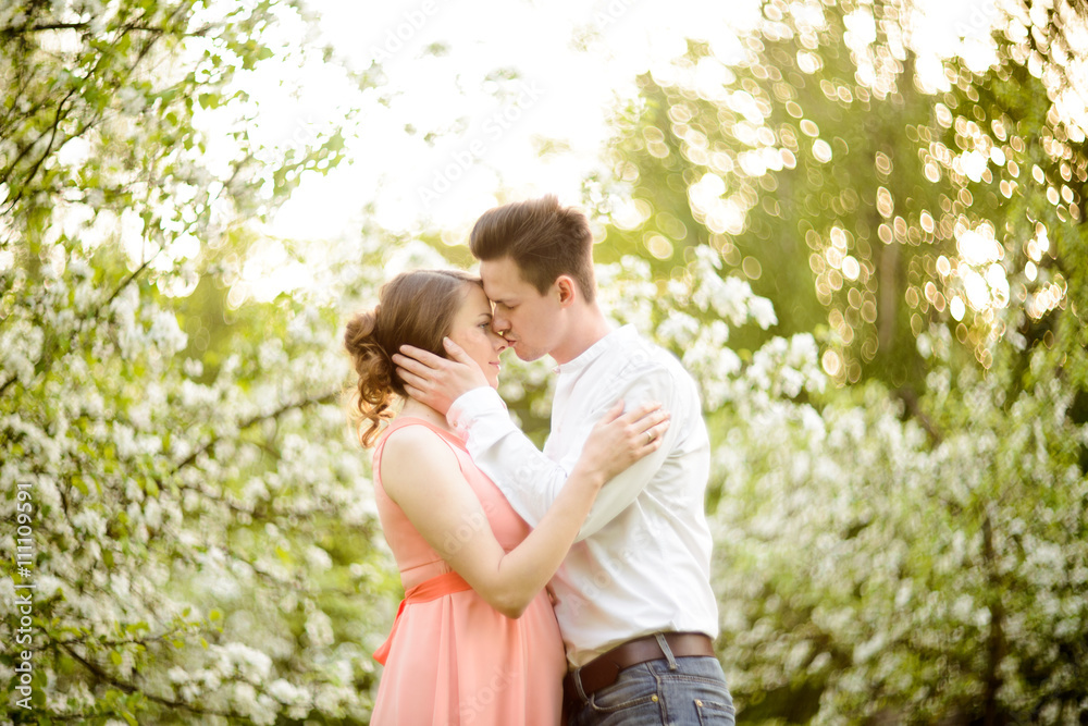 Couple in love under blooming branches spring day. Couple in love under blooming branches spring day.