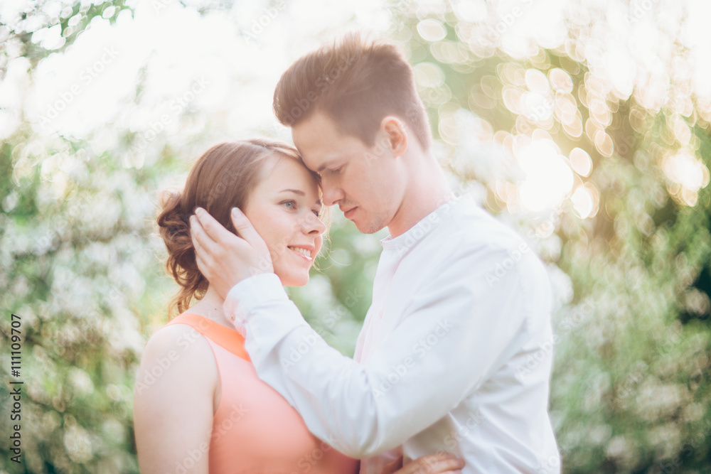 Couple in love under blooming branches spring day.