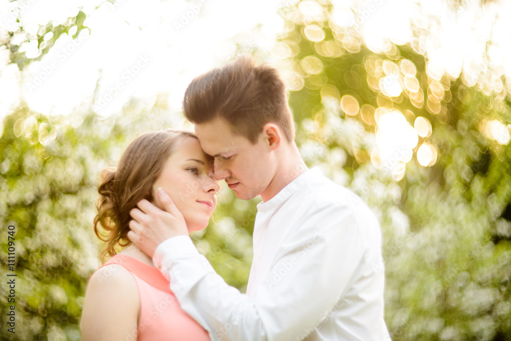 Couple in love under blooming branches spring day. Couple in love under blooming branches spring day.