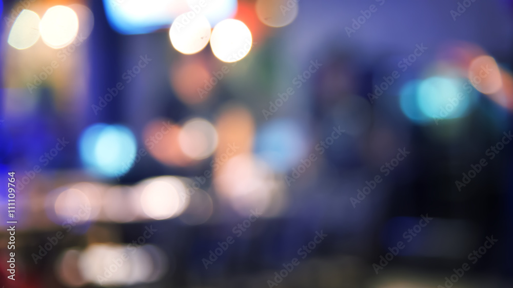 Blurred defocused of light in pub city abstract background with blue night tone