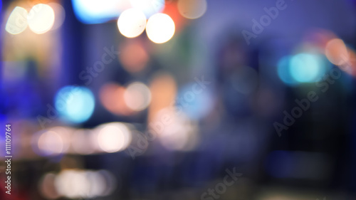 Blurred defocused of light in pub city abstract background with blue night tone