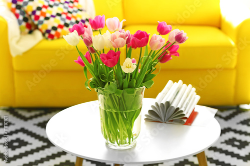 Beautiful fresh tulips on round table