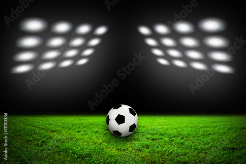 Soccer ball on grass against black background