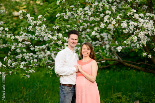 Couple in love under blooming branches spring day.