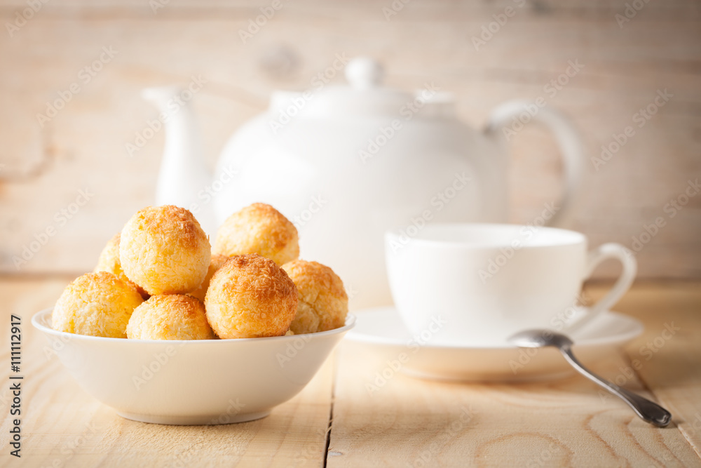Fresh homemade coconut cookies in white bowl on wooden background. Sweet afternoon with tea. Fresh homemade coconut cookies in white bowl on wooden background. Sweet afternoon with tea.