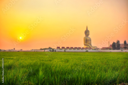 Фотография ANGTHONG THAILAND - MARCH 6: Biggest buddha is in Wat Muang with sunset at the f