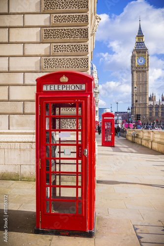London, UK - Iconic Red British telephone box with Big Ben on a sunny afternoon