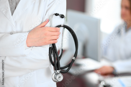 Female doctor standing in a hospital with her colleague in the background