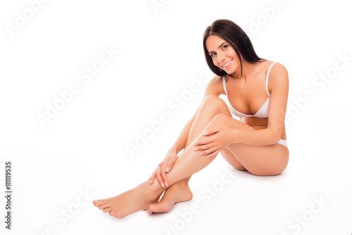 Pretty woman in white underwear doing massage for her legs © deagreez
