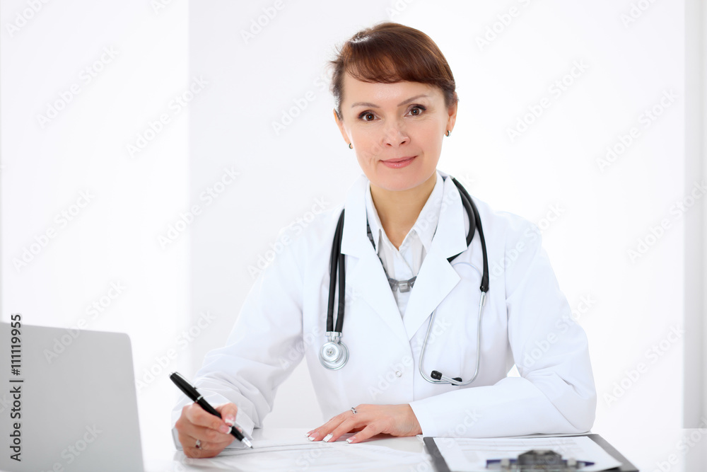 Woman doctor filling up medical history at the desk Woman doctor filling up medical history at the desk
