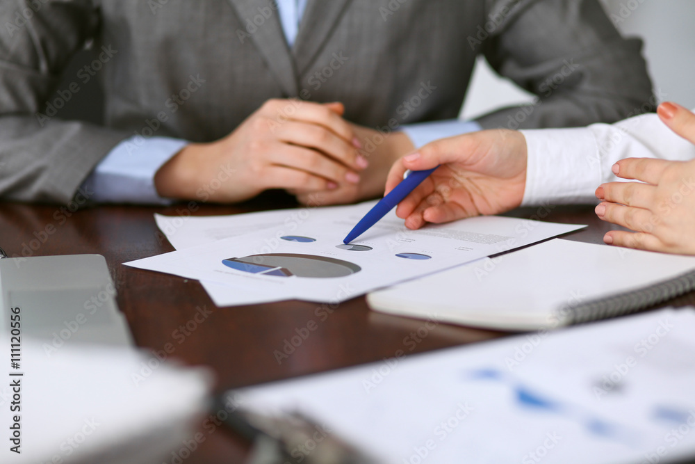 Close up of unknown business people at meeting discussing financial results Close up of unknown business people at meeting discussing financial results