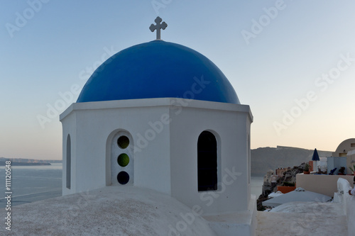 Church with blue roof in town of Oia and panorama to Santorini island, Thira, Cyclades, Greece