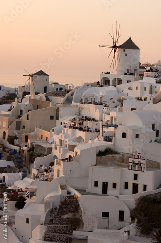 Amazing Sunset over white windmills in town of Oia and panorama to Santorini island, Thira, Cyclades, Greece