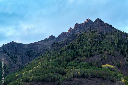 mountain peak, illuminated by last rays of setting sun photo