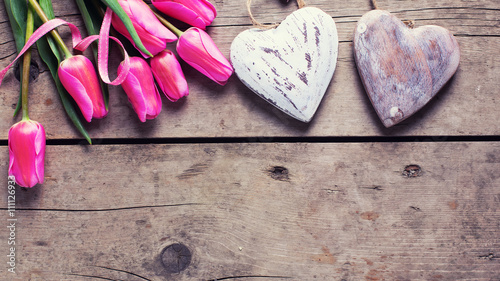 Bright pink spring tulips  and two decorative hearts