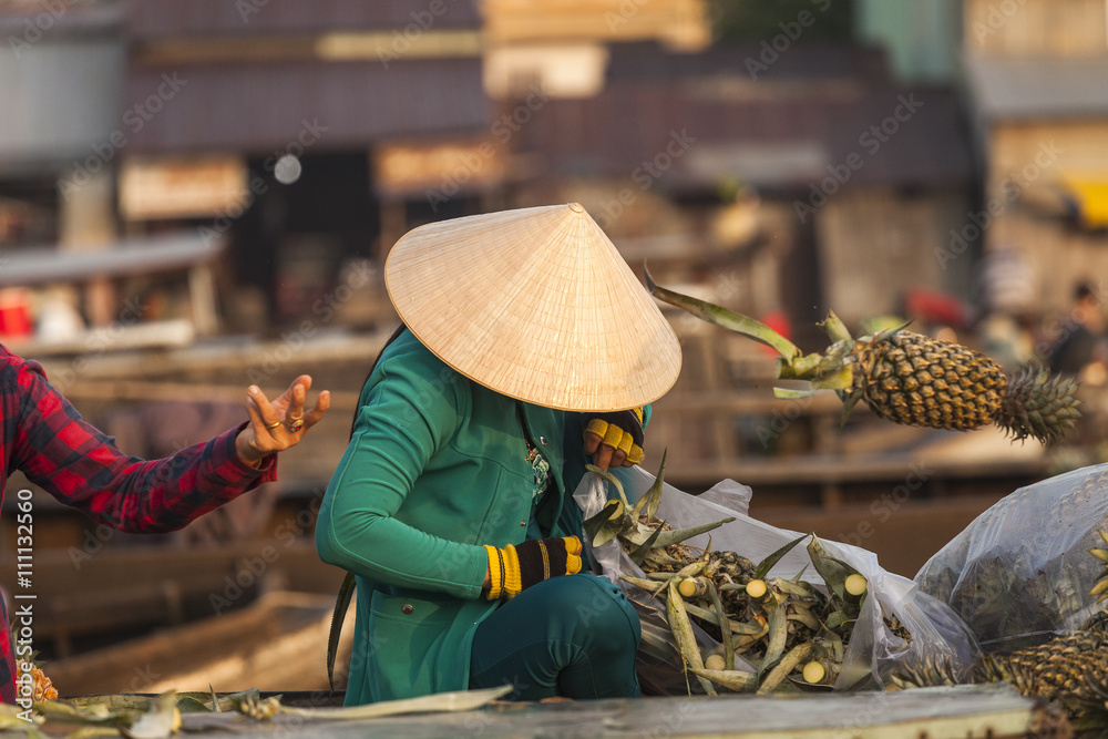 Foto Stock Vietnamese woman with typical conical hat ( sugegasa), cut  pineapple fruits in the Cai Rang floating market on the Mekong delta. Can  Tho, Vietnam | Adobe Stock