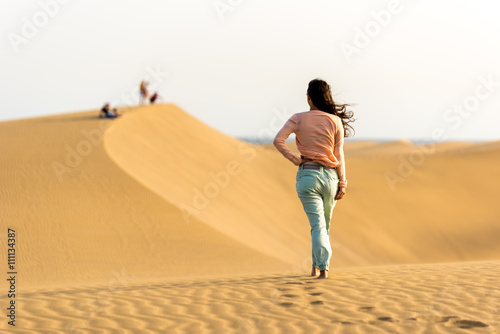 Girl walking on sand dunes in Gran Canaria, Spain