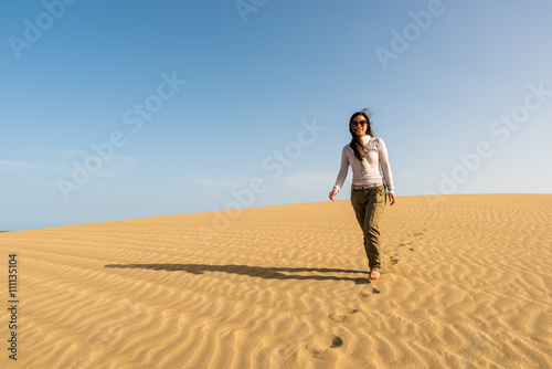 Girl walking on sand dunes in Gran Canaria, Spain © Simon Dannhauer