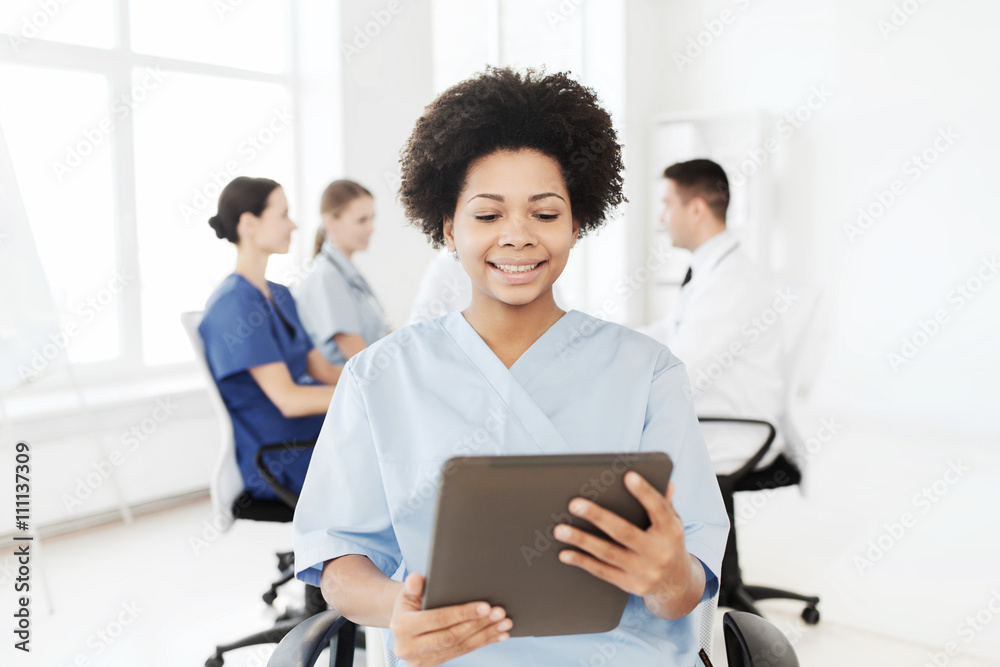 happy nurse with tablet pc over team at hospital happy nurse with tablet pc over team at hospital