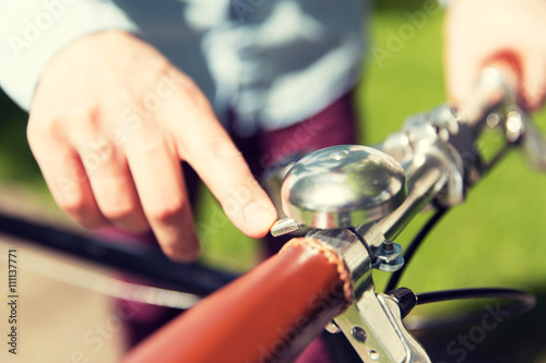 close up of male hand ringing bell on bike wheel