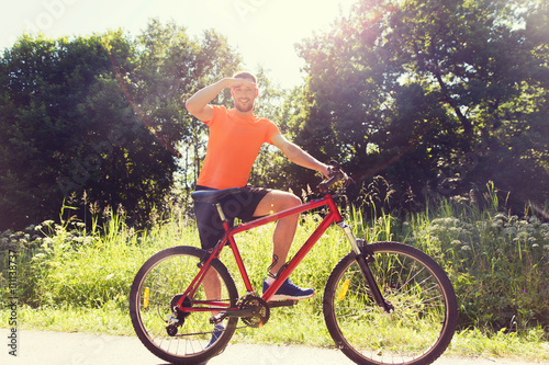 Fototapeta Naklejka Na Ścianę i Meble -  happy young man riding bicycle outdoors
