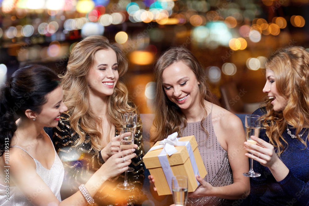 happy women with champagne and gift at night club happy women with champagne and gift at night club