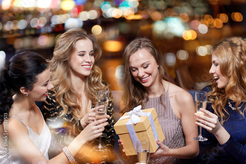 happy women with champagne and gift at night club