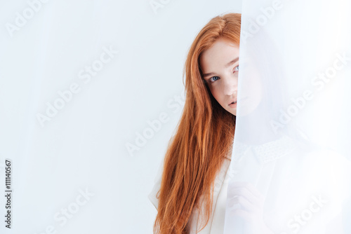 Woman peeking from curtain