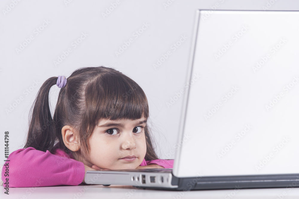 Cute little girl with laptop computer. Education, technology and e-learning concept Cute little girl with laptop computer. Education, technology and e-learning concept