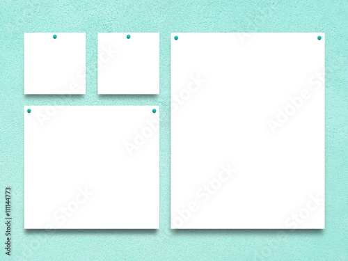 Close-up of four nailed square and rectangular blank frames on aqua rough wall background