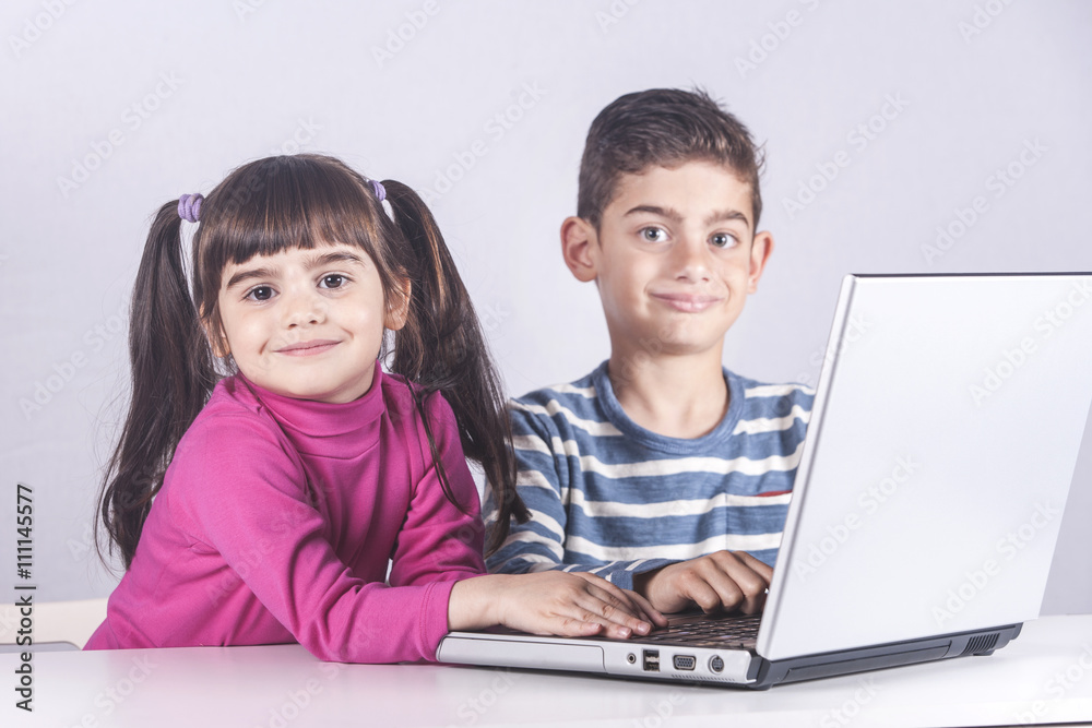 Kids having fun using a laptop computer. Education, technology and e-learning concept Kids having fun using a laptop computer. Education, technology and e-learning concept