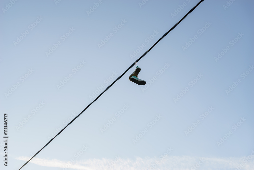 Sneakers dangling on power line cable