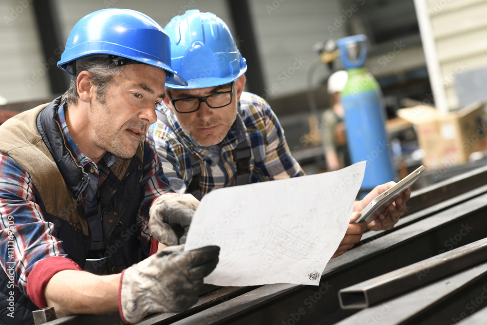 Engineers working on project in metallurgy workshop Engineers working on project in metallurgy workshop