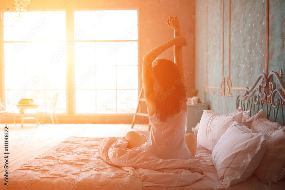 Woman stretching in bed after wake up - obrazy, fototapety, plakaty 