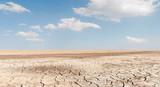 Soil drought cracked landscape on blue sky background