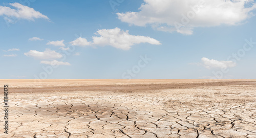 Soil drought cracked landscape on blue sky background