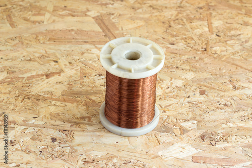 old copper wire rolled on chipboard background