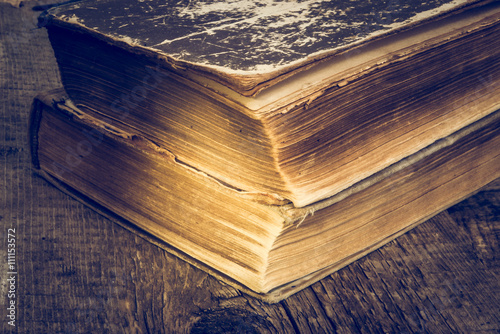 Old books on wooden table in a grunge style. Color toned